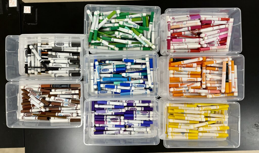 Picture of colored markers organized in bins.