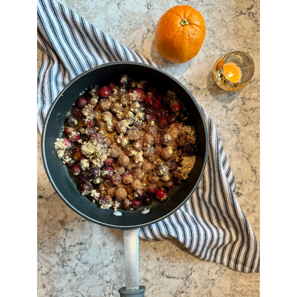 Photo of 24 ounces of fresh cranberries, 1 cup packed dark brown sugar (light brown sugar will work as well; dark brown is my personal preference), 1 1/2 cups water, 1 medium orange, 3/4 cup orange juice, 1 teaspoon ground ginger ,1 teaspoon ground cinnamon in medium sauce pan on white and grey quartz counter top of best cranberry sauce ever recipe.