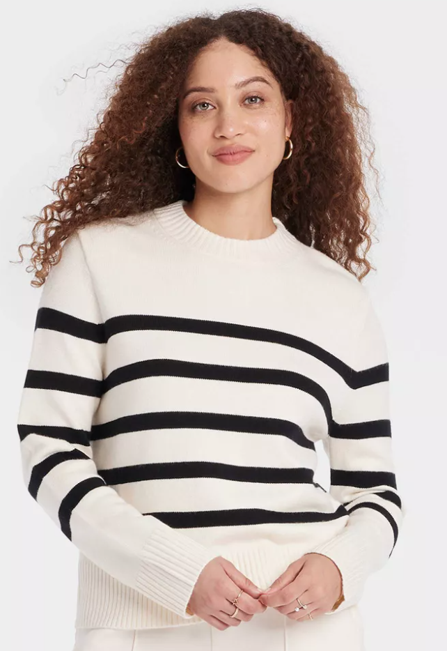 Woman with curly hair in white sweater with black stripes. Link included for purchase.