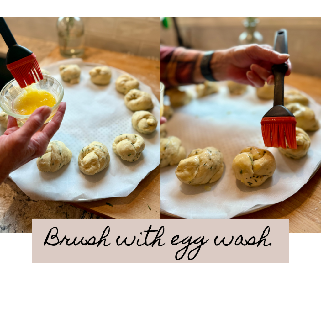 2 images of a woman putting an egg wash on the bread wreath knots. She is using a silicon pastry brush and rolls are on parchment paper.