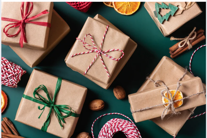 Image of presents wrapped in brown paper with red and green ribbon and a dark green background for Favorite Things Party blog post. 