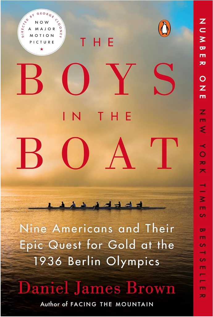 Image of book club recommendation for "The Boys In The Boat". Image is over 9 men rowing in a boat on water and the sky behind them is yellow and blue and cloudy. 