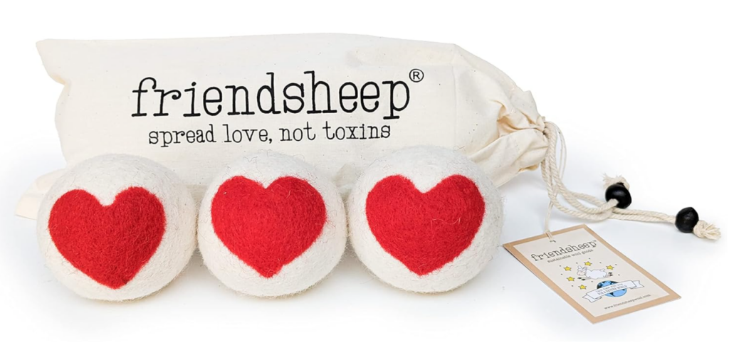 minimalist household essentials. Image of 3 wool dryer balls with red hearts on them in front of a cloth bag that says "friendsheep: spread love not toxins."