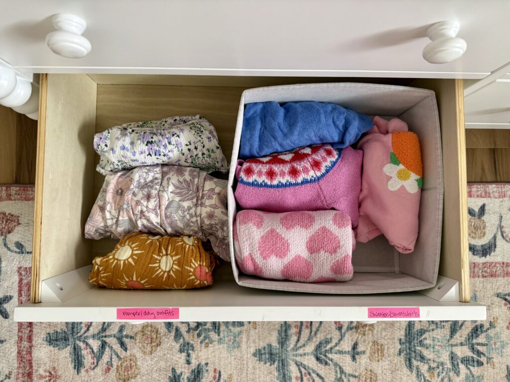girl nursery decor ideas pink. dresser with open drawer to show clothes being organized in drawer organizers.