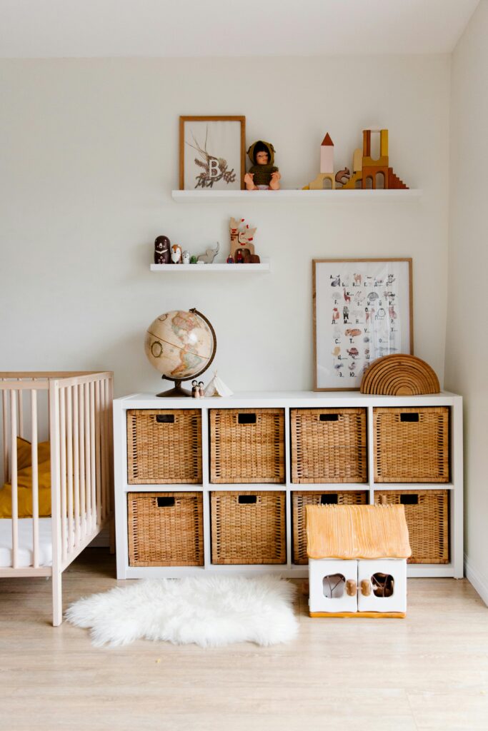 baby registry essentials. Image of baby nursery including a crib, book shelf, and shelves with toys.
